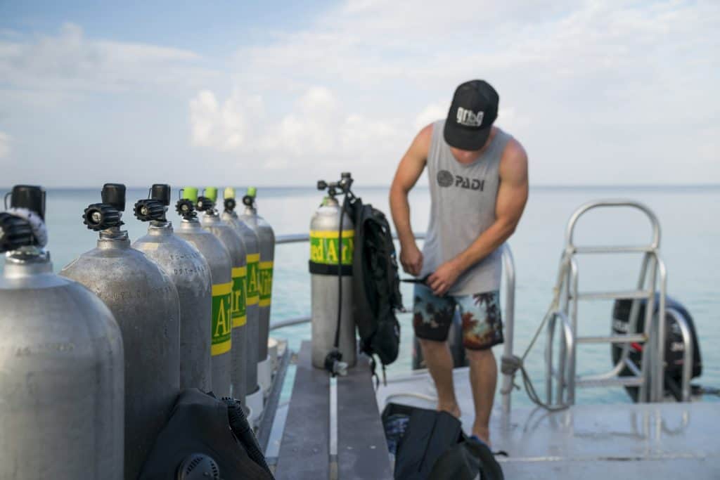 Enriched air (Nitrox) cylinders marked with the standard green-and-yellow band, lined up on a dive boat